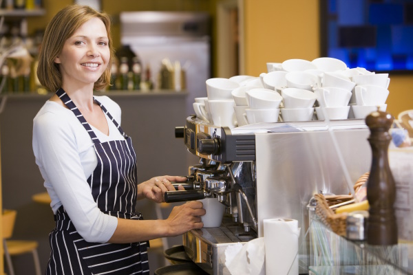 Frau im Kaffehaus beim Kaffee machen